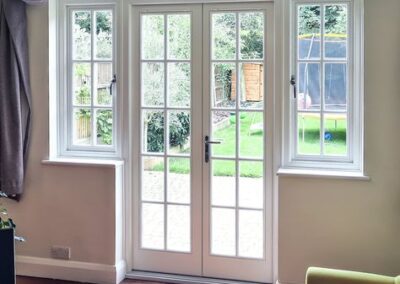 White finish timber double doors and flank windows with Georgian astragal bars